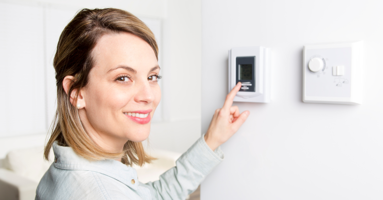 Woman controlling a thermostat